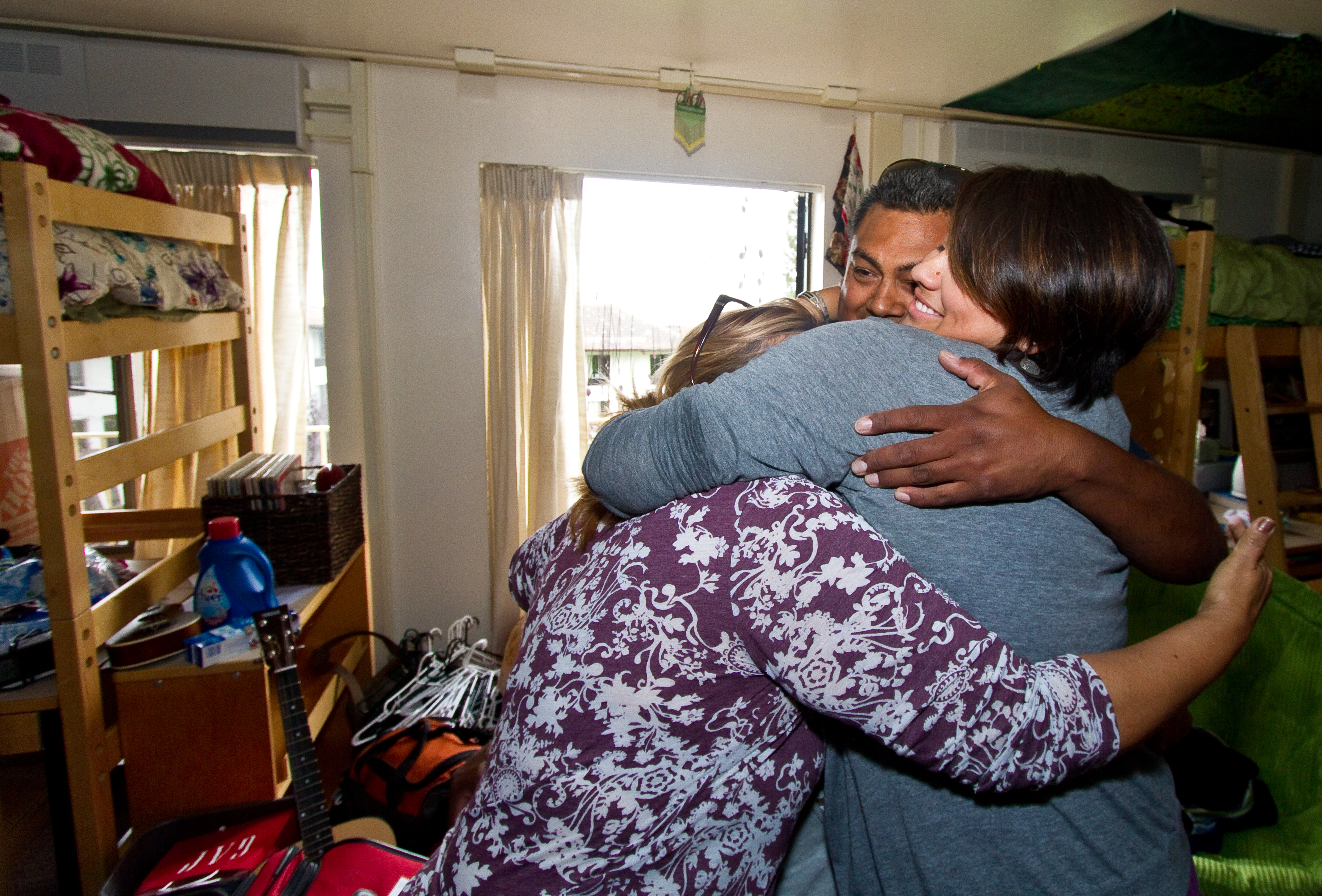 photo of parents and student hugging in a residence hall